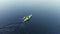Aerial video of girl with red long hairs kayaking in green sea kayak in blue water. Close up tracking shot - flight behind the