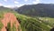 Aerial video of pink rocks with scarce vegetation and distant snow covered peaks