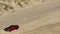 Aerial video red pick up truck driving on beach sand at high speed