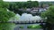 Aerial of video of rising up and moving forward showing riverside pub, weir, housing estate and nature