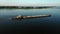 Aerial video river pusher boat transporting barge with dry cargo in middle of summer river, Central Europe