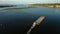 Aerial video river pusher boat transporting barge with dry cargo in middle of summer river, Central Europe