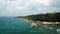 Aerial video of tropical island coastline with clear azure ocean, rocky shores, lush palm and coconut trees. Waves