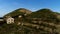 Aerial view of the abandoned village located between the hills. Shot. Picturesque mountains and cliffs covered by green