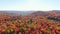 Aerial view above the colorful mountains of Autumn moving down slowly and showing the lakes, rivers and mist in the landscape