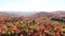 Aerial view above the colorful mountains of Autumn moving down slowly and showing the lakes, rivers and mist on the mountains