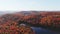 Aerial view above the colorful mountains of Autumn moving from right to left and showing the lakes and mist in the landscape