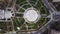 Aerial view from above of construction site in the park or city square. Workers laying paving slabs near fountain in the