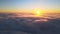 Aerial view from above at high altitude of dense puffy cumulus clouds flying in evening. Amazing sunset from airplane