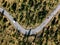 Aerial view from above of a rural landscape with a curvy road and white car in Italy