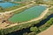 Aerial view of an active gravel pond beside the river Leine near Sarstedt, Germany, with a truck and piles of sand