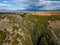 Aerial view of the Aggitis canyon in Greece offers a breathtaking aerial view of the winding river, steep cliffs, and lush