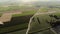 Aerial view with agricultural fields and orchards intersected by narrow roads.