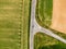 Aerial view of agriculture fields, meadow and road inside. Rural scene of countryside. Fresh green colors, look to above tree. Day