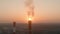 Aerial view of air polluting smoke stack at sunset