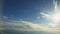 Aerial view from aircraft window on white fluffy clouds quickly fly on blue sky