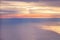 Aerial view from airplane of bright colorful pink red yellow orange sun beams in clouds on light blue sky at sunset sunrise.