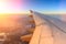 Aerial view of airplane flying above shade clouds and sky from an airplane fly during the sunset. View from the plane window.