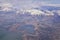 Aerial view from airplane of the Wasatch Front Rocky Mountain Range with snow capped peaks in winter including urban cities of Pro