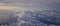 Aerial view from airplane of the Wasatch Front Rocky Mountain Range with snow capped peaks in winter including urban cities of Pro