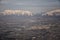 Aerial view from airplane of the Wasatch Front Rocky Mountain Range with snow capped peaks in winter including urban cities of Pro