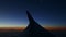 Aerial view from airplane window across steel wing silhouette at dark sunset sky