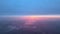 Aerial view from airplane window at high altitude of distant city covered with layer of thin misty smog and distant