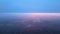 Aerial view from airplane window at high altitude of earth covered with white thin layer of misty haze and distant