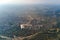 Aerial view from airplane window at high altitude of earth covered with white thin layer of misty haze and distant