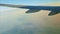 Aerial view from airplane window on steel wing fly above green land and white fog