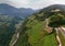 Aerial view of the alpine vineyards on a summer day. flat rows of fields, farms, small village of Faver, famous for wine