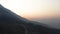 Aerial view of Alps mountains during sunrise and morning haze. HDR. Beautiful forested slope of a giant hill and