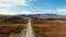 Aerial view of amazing road with view of the Caucasian ridge and Mount Elbrus. Highway runs through green meadow. Light