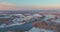 Aerial view of amazing winter sunset in suburb city with snow covered residential quarters by the river