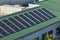 Aerial view of american condo building roof with blue solar photovoltaic panels for producing clean ecological electric