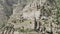 Aerial view of an ancient abandoned stone village with ruined buildings. Action. Rock cliff with old towers and