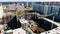 Aerial view of apartment buildings at construction site with four working cranes. Motion. The process of developing of