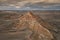 Aerial view of an arid and isolated mountain in a cloudy afternoon in the Spanish Badlands