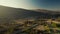 aerial view asphalt road and locomotive moving by railway at sunny sunrise in country side in mountain valley in