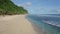 Aerial view athlete runs alone on sandy beach, ocean and mountains on background