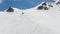 Aerial view athlete skier freerider stands atop the sidelines high in the mountains preparing to descend down. Skitour