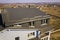 Aerial view of attic annex room exterior with plastic windows, roof and walls covered with brown metal decorative siding planks,