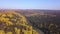 Aerial view of autumn forest and small lake. Clip. Breathtaking panoramic aerial view of the hills of colorful orange