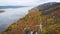 Aerial view. Autumn, a large river among the forest hills. The trees are already in yellow and orange leaves. Seasons