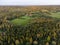 Aerial view of autumnal green field and trees in Sweden.