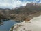 Aerial view of azure mountain lake Gizhgit, Caucasus. Blue water shimmers in sunlight. High majestic mountain range is