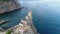 Aerial view of the back of swallow nest castle in Yalta, Crimea. Flying over rocky blue sea shore.