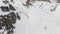 Aerial view of a backcountry skier rides in orange clothes freeride on a steep slope makes drop jump. Professional ski