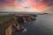 Aerial view of the Ballycotton cliff walks and its lighthouse in the distance in county Cork, Ireland, at sunrise