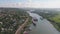 Aerial view: barges on the river, village on the shore, shipyard